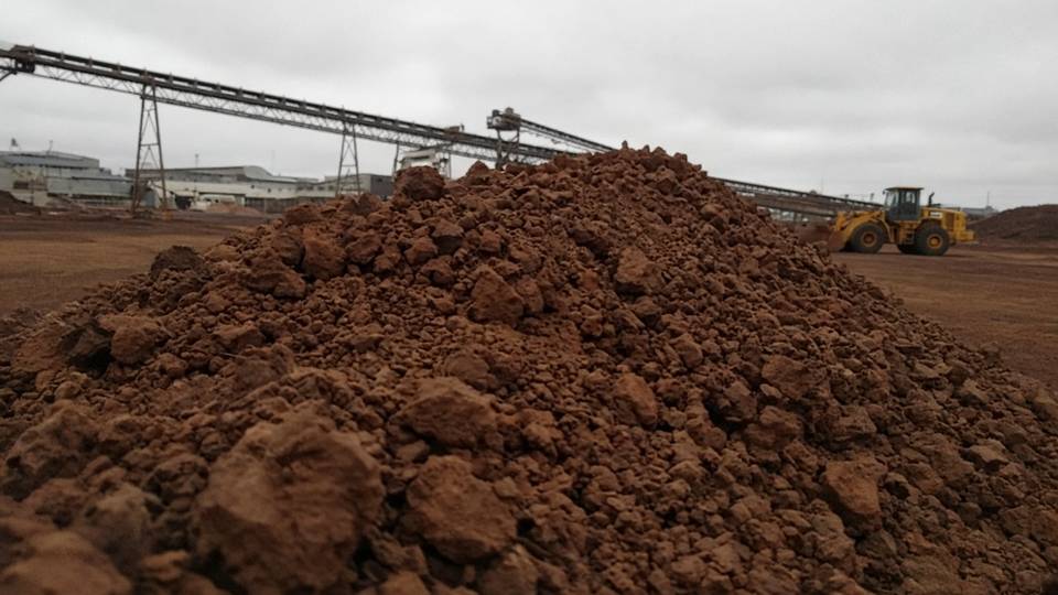 Cumulo di minerale di ferro in pezzi in un piazzale di carico